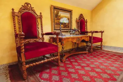 a room with two chairs and a wooden table at Hotel Grande in Celje