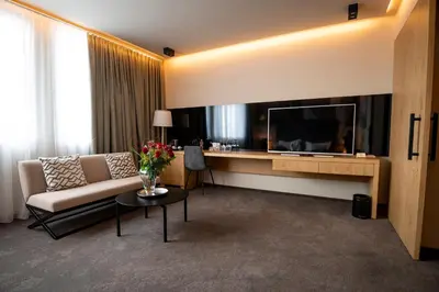 a living room with a couch and a large television at Safir Hotel Casino in Sežana