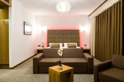 a hotel room with a bed and a couch at Safir Hotel Casino in Sežana