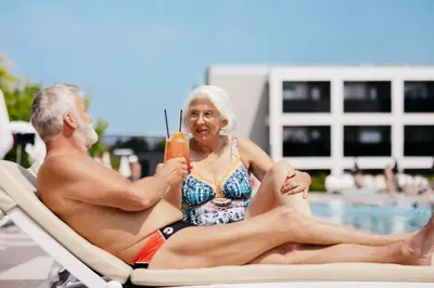 a man and a woman sitting on a beach chair at Hotel Vivat in Moravske Toplice