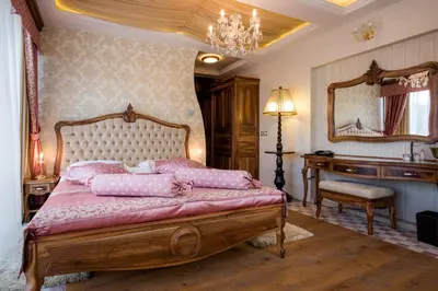 a bedroom with a bed and a desk and a mirror at Grand Hotel Donat Superior & Wellness Center in Rogaška Slatina