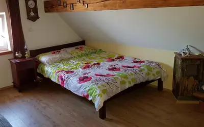 a bedroom with a bed with a floral comforter at Apartma Lipek in Pristava