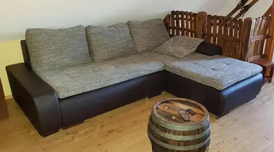 a black couch and a barrel in a living room at Apartma Lipek in Pristava