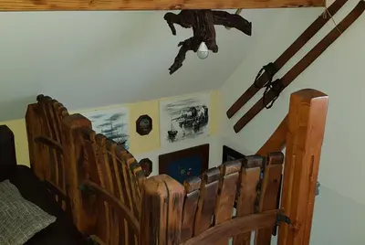 a row of wooden pews in a church with a monkey on the ceiling at Apartma Lipek in Pristava