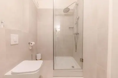 a white bathroom with a shower and a toilet at AB Ljubljana - The Residence in Ljubljana