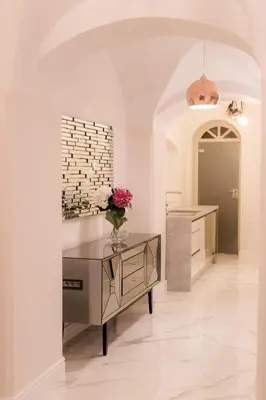 a white room with a table and flowers on it at AB Ljubljana - The Residence in Ljubljana