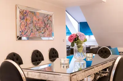 a vase of flowers on a table with chairs at AB Ljubljana - The Residence in Ljubljana