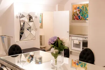 a kitchen with a vase of flowers on a table at AB Ljubljana - The Residence in Ljubljana