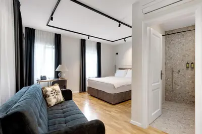 a bedroom with a bed and a couch in a room at Bloom Hotel in Ljubljana