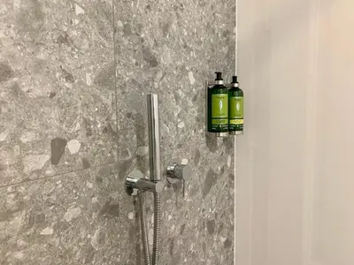 a bathroom with a shower with a bottle of soap at Bloom Hotel in Ljubljana