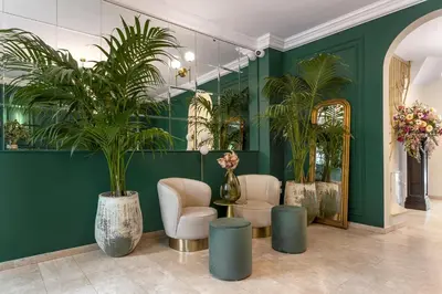 a lobby with green walls and potted plants at Bloom Hotel in Ljubljana