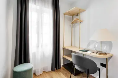 a room with a desk and a chair and a window at Bloom Hotel in Ljubljana
