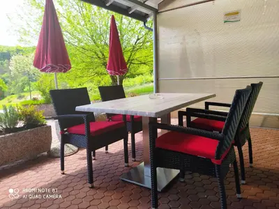 a table and chairs on a patio with umbrellas at Apartment Lucija-Terme Šmarješke Toplice in Smarjeske Toplice