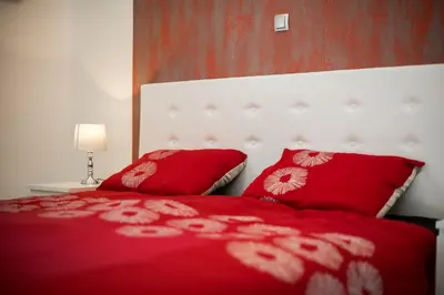 a bedroom with a red bed with red pillows at Apartment Lucija-Terme Šmarješke Toplice in Smarjeske Toplice