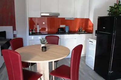 a kitchen with a wooden table and red chairs at Apartment Lucija-Terme Šmarješke Toplice in Smarjeske Toplice