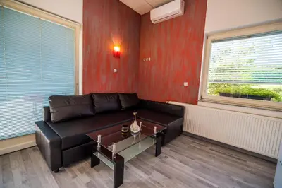 a living room with a black leather couch and a table at Apartment Lucija-Terme Šmarješke Toplice in Smarjeske Toplice