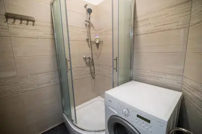 a bathroom with a shower and a washing machine at Apartment Lucija-Terme Šmarješke Toplice in Smarjeske Toplice