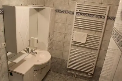 a white bathroom with a sink and a mirror at Guesthouse Veranda in Mojstrana
