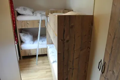 a bunk room with two bunk beds and a door at Guesthouse Veranda in Mojstrana