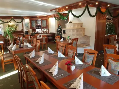 a restaurant with wooden tables and chairs with napkins on them at Guesthouse Veranda in Mojstrana