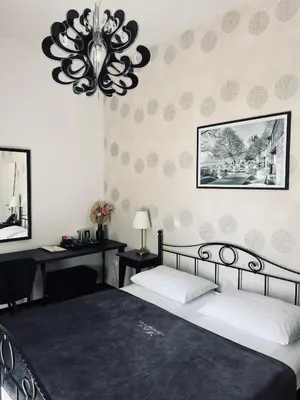 a bedroom with a large bed and a chandelier at Penzion Vila Prešeren in Bled