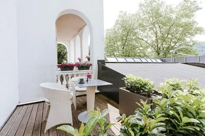 a patio with a table and chairs on a balcony at Penzion Vila Prešeren in Bled