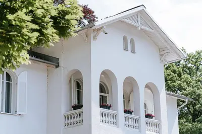 a white house with flower boxes on the windows at Penzion Vila Prešeren in Bled