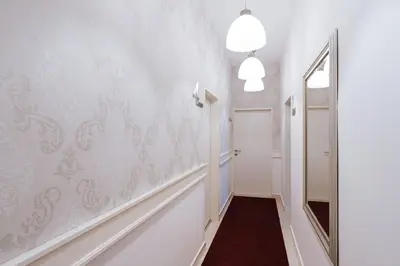 a hallway with white walls and a mirror at Penzion Vila Prešeren in Bled