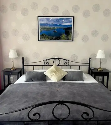 a bedroom with a large bed with two night stands at Penzion Vila Prešeren in Bled