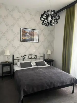 a bedroom with a large bed and a chandelier at Penzion Vila Prešeren in Bled