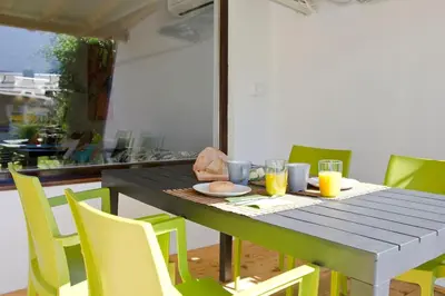 a dining room table with yellow chairs and orange juice at Green Garden Studio in Bovec