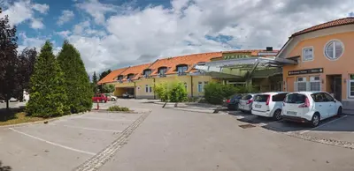 a parking lot in front of a building with cars parked at Penzion Plac ob železnici in Loče pri Poljčanah