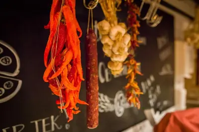 a bunch of carrots and onions hanging from a wall at Penzion Plac ob železnici in Loče pri Poljčanah