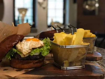 a hamburger and french fries on a table at Penzion Plac ob železnici in Loče pri Poljčanah