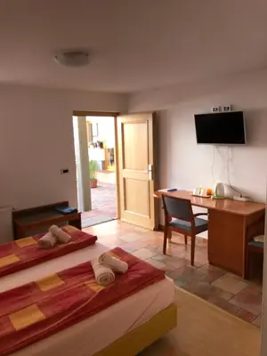 a room with two beds and a desk and a table at Apartments & Rooms Preseren in Bled