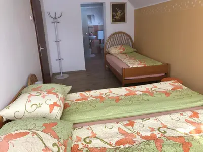 a bedroom with two beds and a room with a mirror at Apartments & Rooms Preseren in Bled