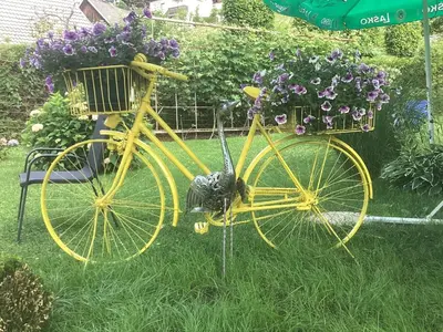 a yellow bike parked in the grass with flowers at Apartments & Rooms Preseren in Bled