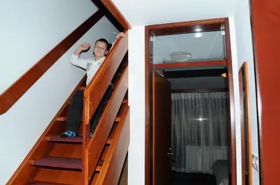 a boy on the stairs of a tiny house at Hotel Tripič, restaurant and pizzeria in Bohinj