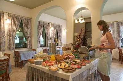 a woman standing next to a table full of food at Hotel Tripič, restaurant and pizzeria in Bohinj