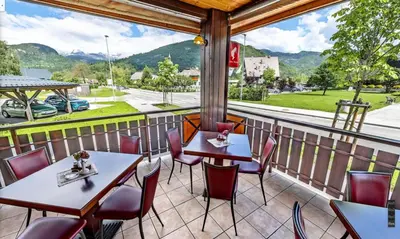 a balcony with tables and chairs and a view of a street at Hotel Tripič, restaurant and pizzeria in Bohinj