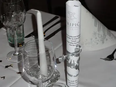 a table with two candles and wine glasses on it at Hotel Tripič, restaurant and pizzeria in Bohinj
