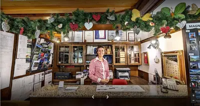 a woman standing behind a counter in a store at Hotel Tripič, restaurant and pizzeria in Bohinj