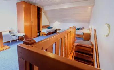 a room with two beds and a staircase in a room at Hotel Tripič, restaurant and pizzeria in Bohinj
