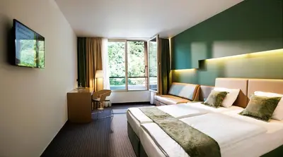 a hotel room with a large bed and a window at Hotel Thermana Park Laško**** Superior in Laško