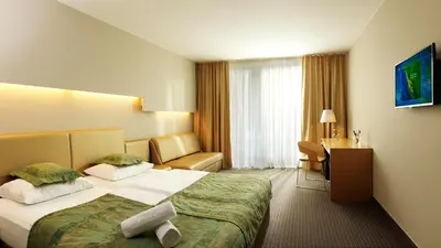 a hotel room with a bed and a desk at Hotel Thermana Park Laško**** Superior in Laško