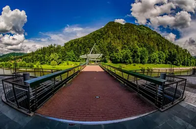 a bridge with a mountain in the background at Hotel Thermana Park Laško**** Superior in Laško