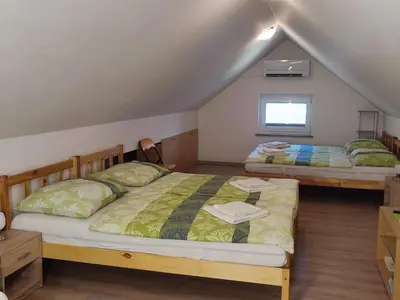 two beds in a room with a attic at Apartment Jelovca - in the attic in Radovljica
