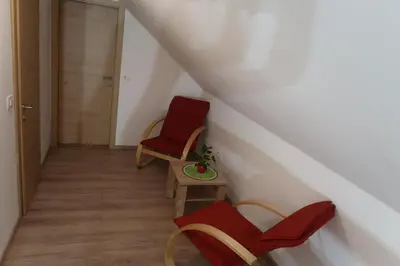 a room with two chairs and a table and a door at Apartment Jelovca - in the attic in Radovljica
