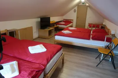 a bedroom with two beds with red sheets at Apartment Jelovca - in the attic in Radovljica