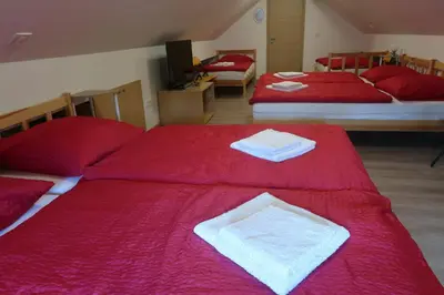 two beds with red sheets and white towels on them at Apartment Jelovca - in the attic in Radovljica